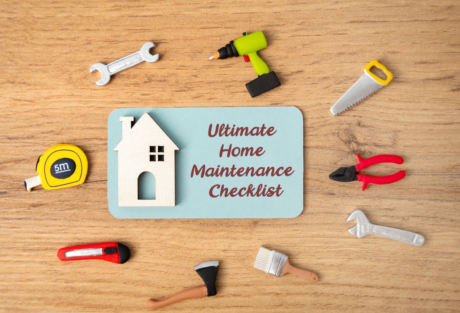 Ultimate home maintenance checklist concept. Tasks to keep your housing safe, efficient, and in good condition. Notes, house and repair tools are on the table